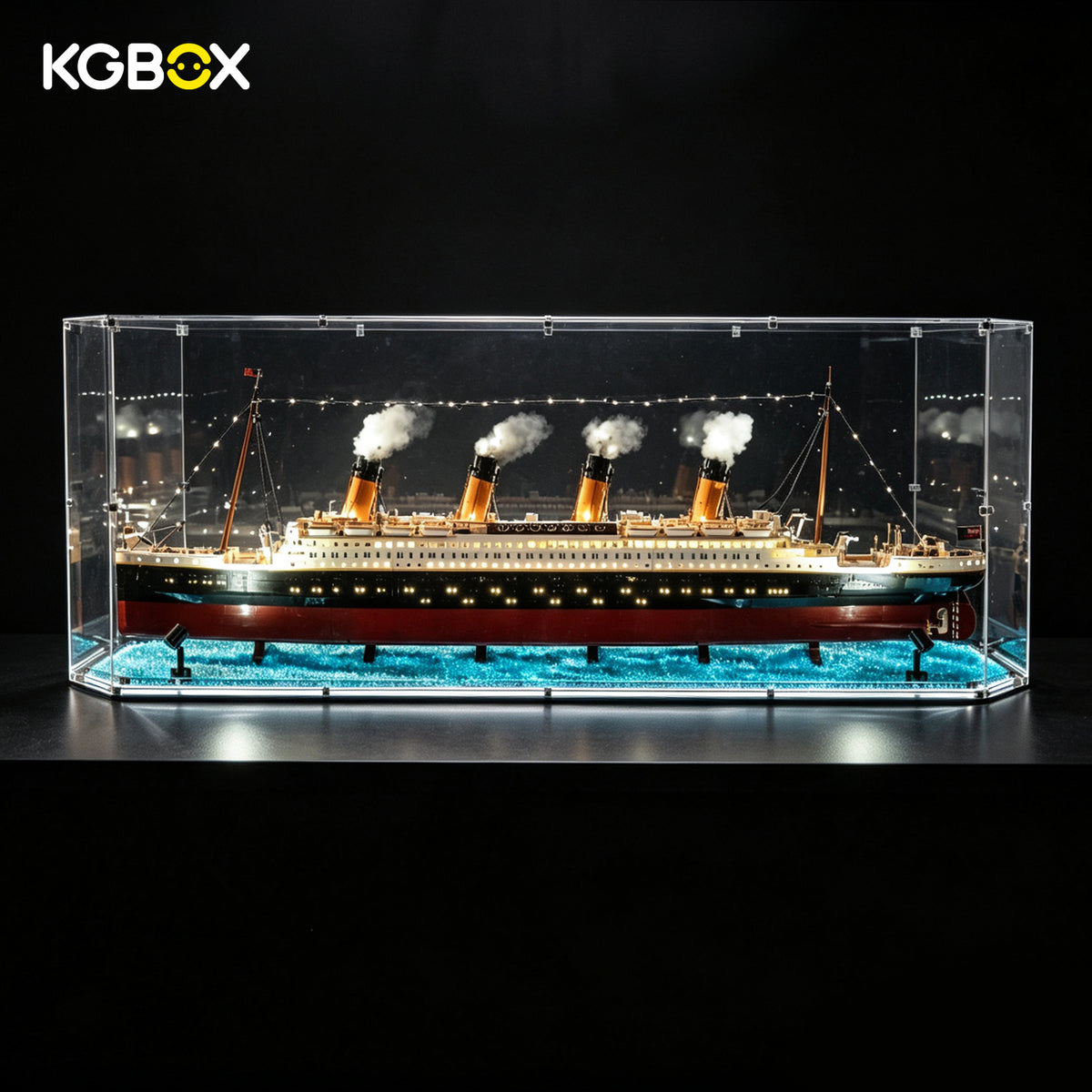 KGBOX gem-shaped acrylic display case for LEGO 10294 Titanic, with lit ship lights, spotlights and ocean-particle base