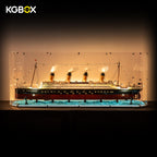 KGBOX gem-shaped acrylic display case for LEGO 10294 Titanic, with lit ship lights, spotlights and ocean-particle base