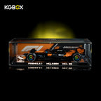 KGBOX premium LED UV tabletop display case for LEGO 42228 McLaren MCL39 F1 car, lit front view with complete Technic championship race car set